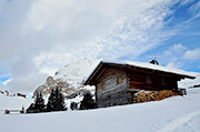 Unsere Almhütte im Winter mit dem Plattkofel und der Bergasthaus Zallinger im Hintergrund